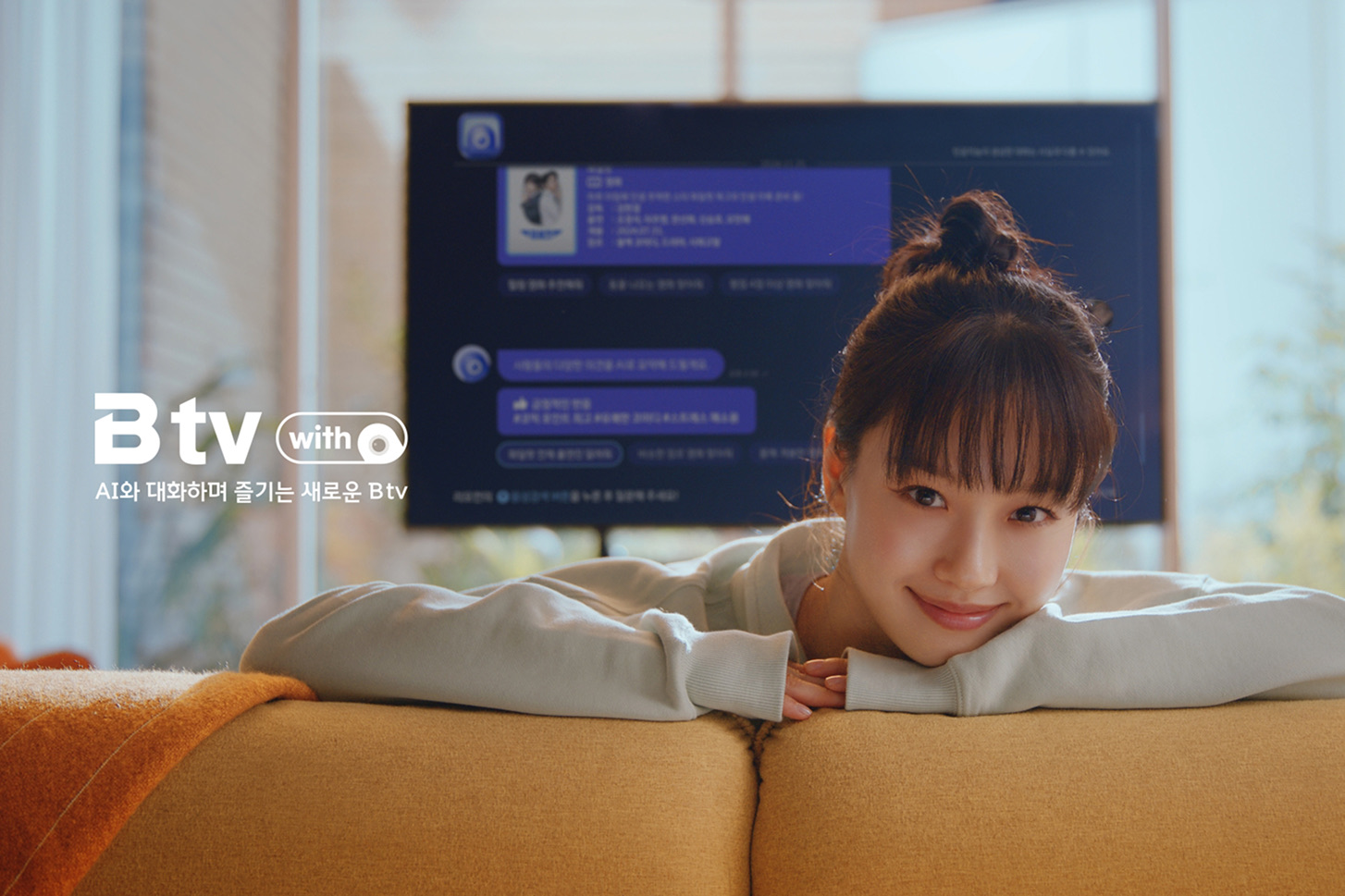 소파에 기대어 B tv 에이닷 화면을 바라보는 여성