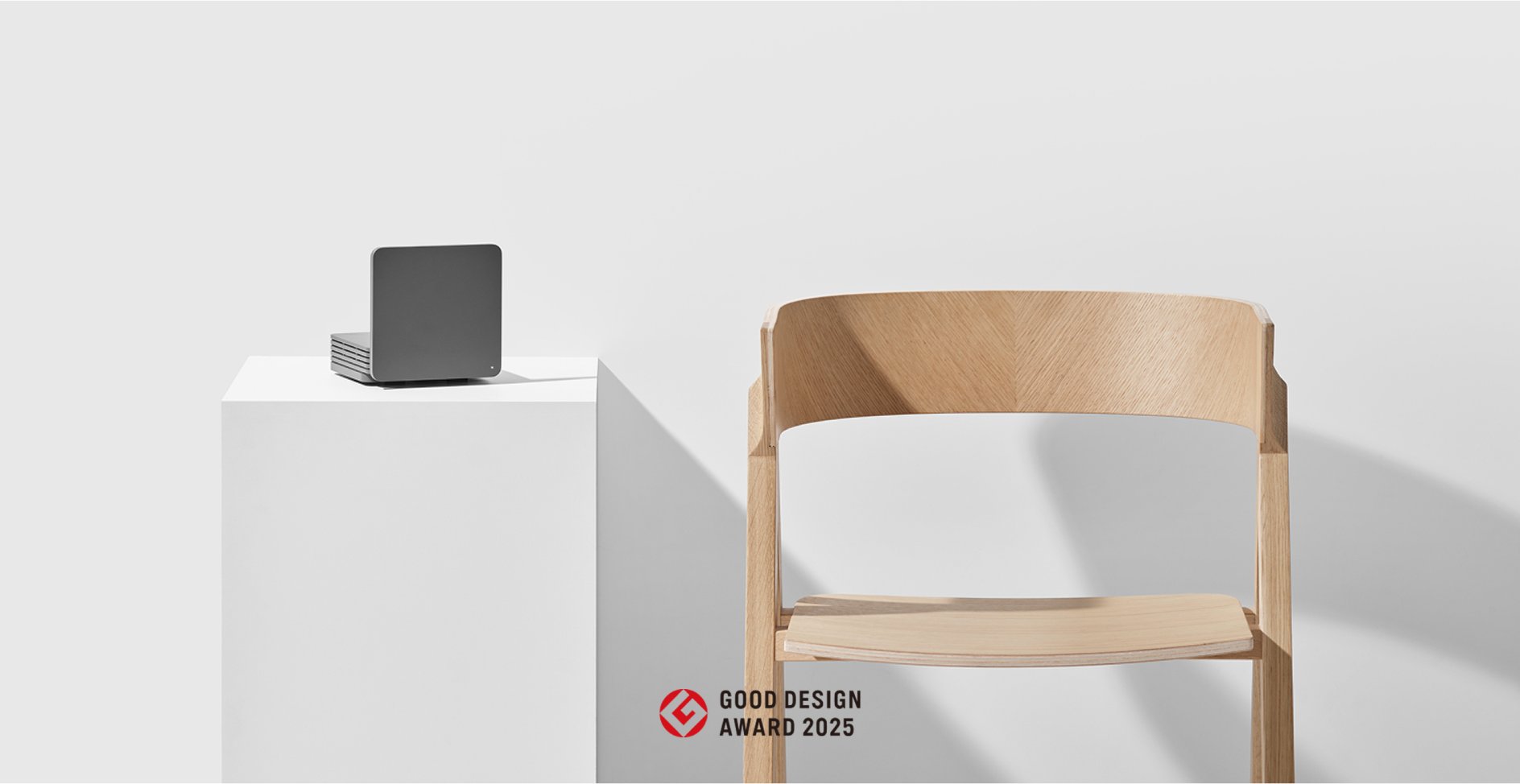 의자 옆 단상 위에 놓인 기가 와이파이 7 기기 — GOOD DESIGN AWARD 2025 수상